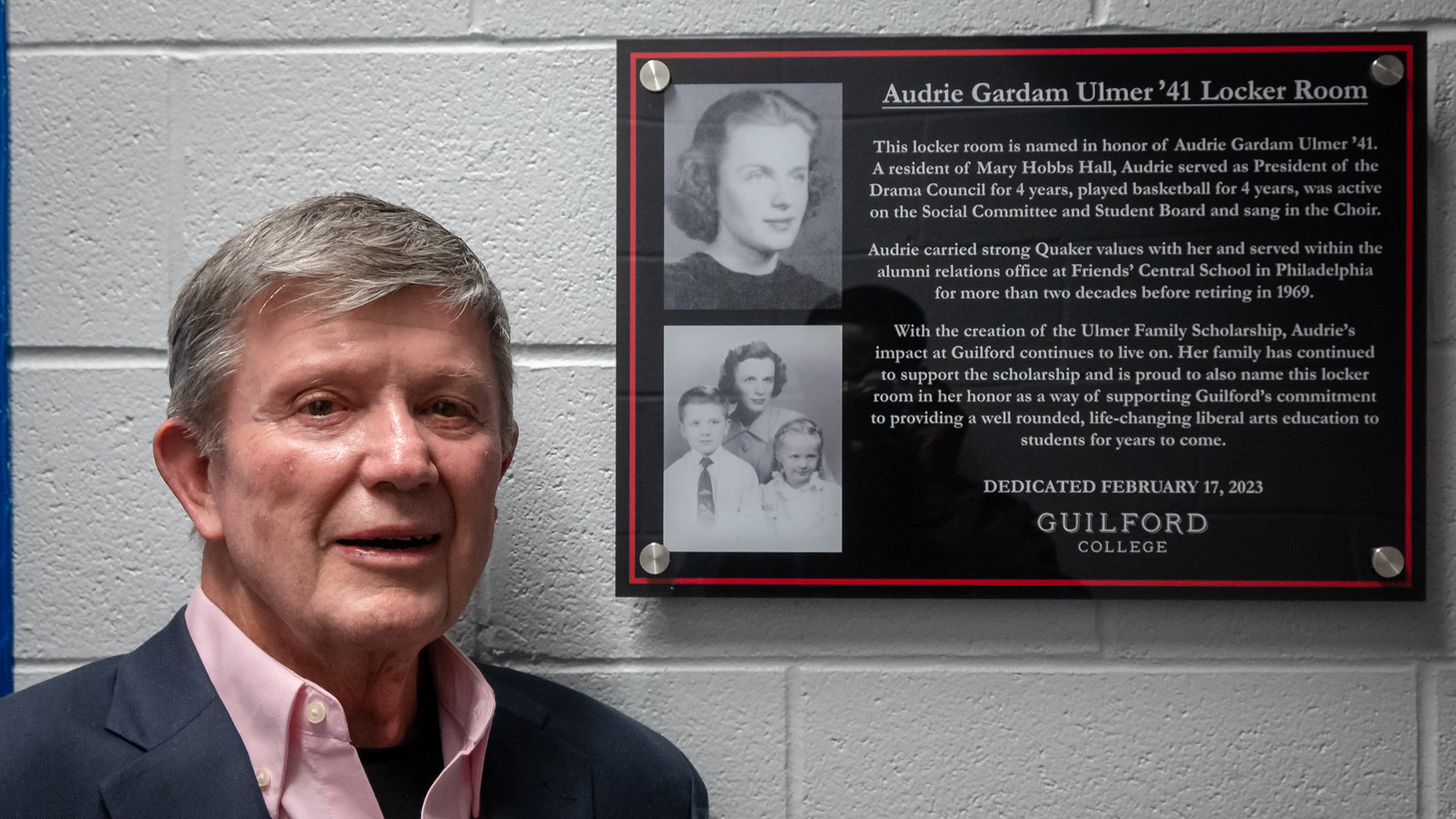 Rich Ulmer with the sign recognizing the naming of the women’s basketball locker room for his mother, Audrie Gardam Ulmer ‘41.